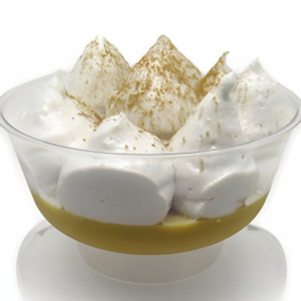 A clear glass bowl filled with a yellow custard base topped with peaks of white meringue, dusted with cinnamon.